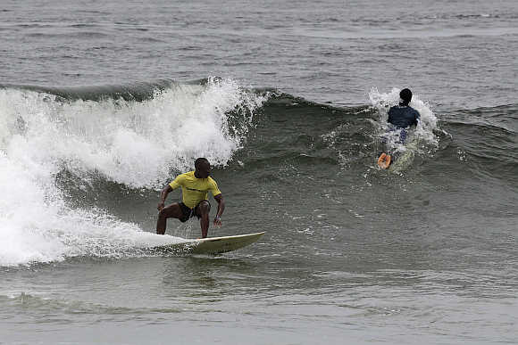 Competitors ride waves at the third annual Surf Liberia Contest at Robertsport on Liberia's coast.