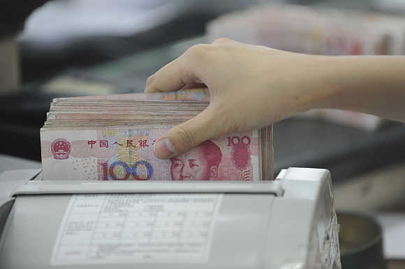 An employee counts yuan banknotes in Hefei, Anhui province, China.
