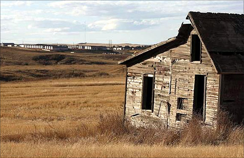 An old farm house sits near a so-called man camp outside Watford, North Dakota.