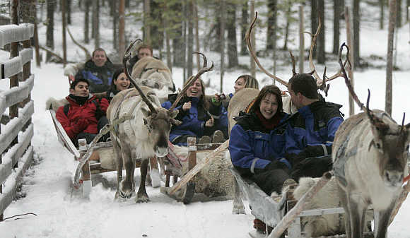 Tourists take part in the reindeer safari at Arctic Circle near Rovaniemi, Finland.