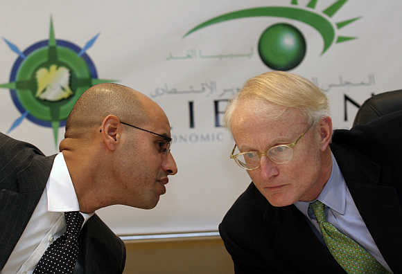 Michael E Porter, right, with Muhammad Gaddafi's son Saif Al Islam, left, in Tripoli, Libya, in a file photo.