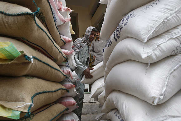 A labourer unloads sacks of rice at a shop in Karachi.