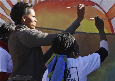 U.S. first lady Michelle Obama paints a mural with teenagers in Botswana