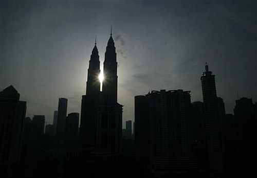 The sun rises behind the Petronas Twin Towers in Kuala Lumpur