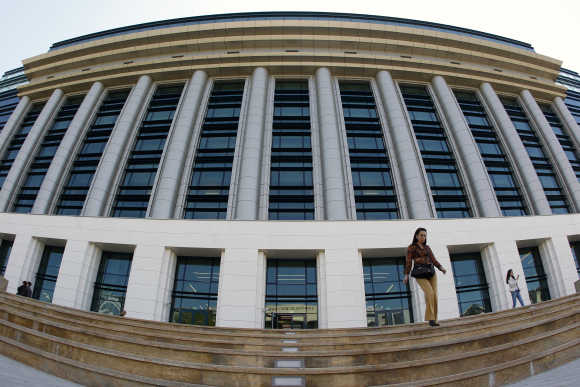 A woman walks down the steps in front of Romania's National Library in Bucharest.