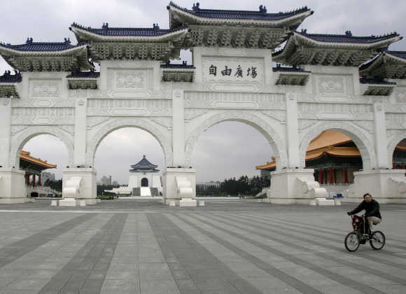 A person rides a bicycle in front of Taiwan's landmark Chiang Kai-shek Memorial hall in Taipei.