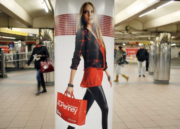 People walk past a JC Penney advertisement in a subway station in Manhattan New York.