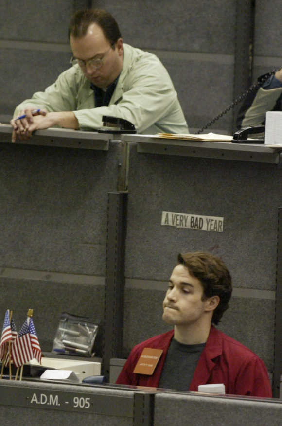 Two members of the Chicago Mercantile Exchange, from Cadent Financial Services, left, and Archer Daniels Midland, right, react to trading in the Live Cattle Pit in Chicago.