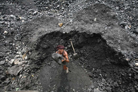 A labourer loads coal onto a truck at a yard on the outskirts of Jammu.