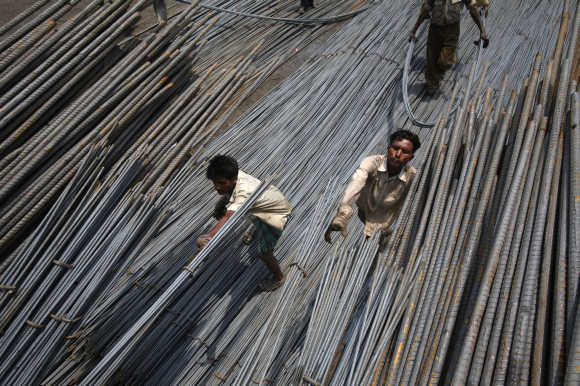 Labourers load steel rods onto a truck at a steel factory on the outskirts of Jammu.