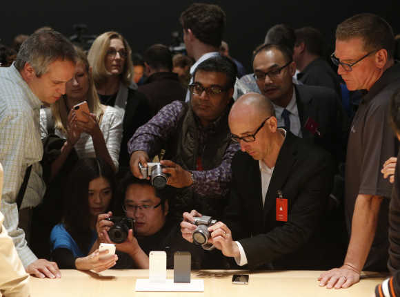 Members of the media photograph the iPhone 5 in San Francisco.
