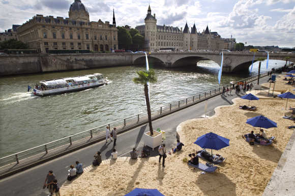 People enjoy the sun along the banks of the River Seine in Paris.