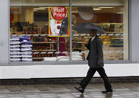 A pedestrian walks past a Tesco store in London.