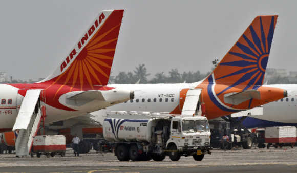 Fuel tanker moves past Air India passenger jets parked at an airport in Kolkata.