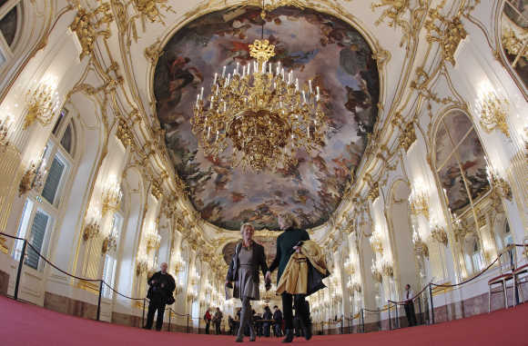 Visitors walk through the Great Gallery hall inside the imperial Schoenbrunn palace in Vienna.
