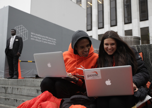 Keenen Thompson and Jessica Mellow (R) surf the web while waiting in line to buy an iPhone 4S at the Apple Store on 5th Avenue in New York.