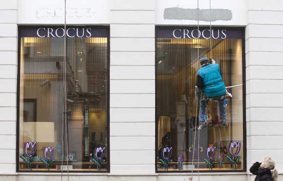 A window cleaner abseils in front of a boutique of the Crocus luxury retailer in Moscow.