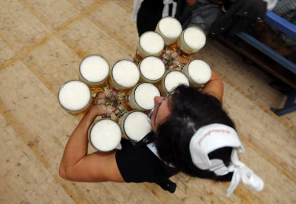 A waitress carries beer after the opening of Oktoberfest in Munich, Germany.
