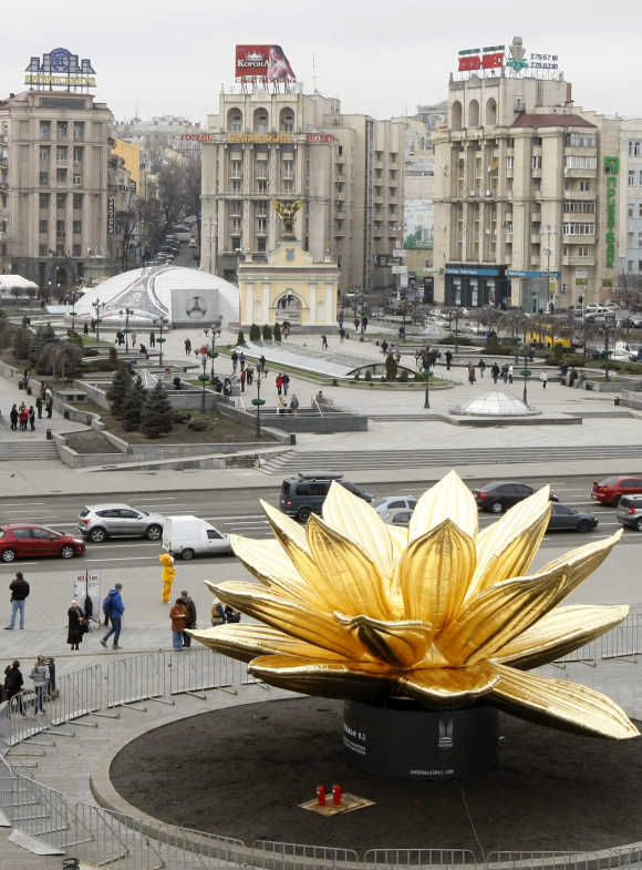 Pedestrians pass an inflatable lotus at Independence Square in Kiev.