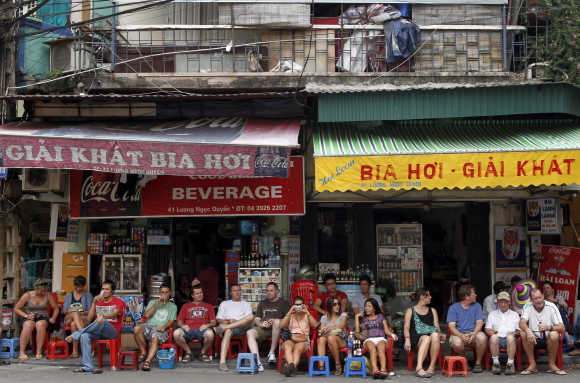Tourists sit on stools and drink beer at the old quarters in Hanoi.