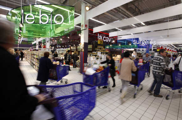 Customers push shopping trolleys inside the Carrefour Planet supermarket in Nice, France.