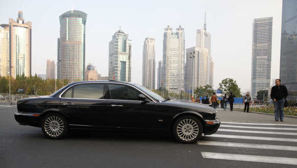 A Jaguar car stops at a pedestrian crossing in the Pu Dong financial district of Shanghai.