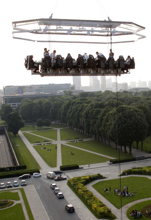Guests enjoy a 'Dinner in the Sky' on a platform hanging in front of the Cinquantenaire park in Brussels.
