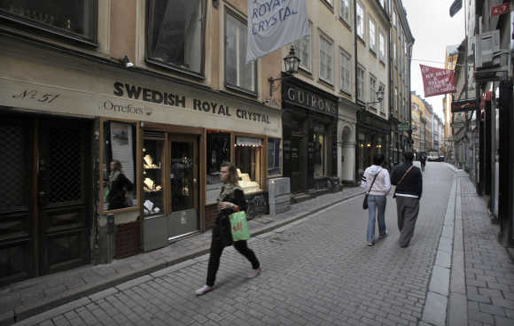 Pedestrians walk down the main shopping street in Stockholm's Gamla Stan or Old Town district.