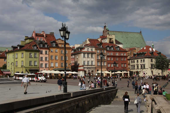 People walk at Plac Zamkowy in Warsaw's Old Town.