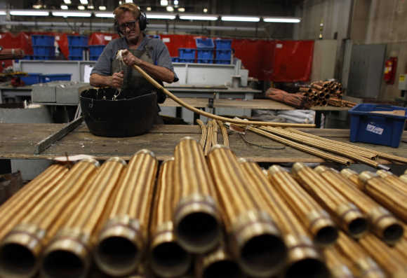 An employee checks a copper hose in Sao Paulo, Brazil.
