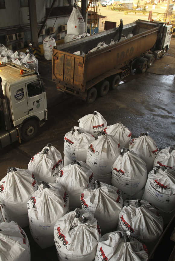 Workers load sacks of nickel ore into trucks in Indonesia's south Sulawesi province.