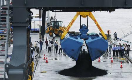 A crane unloads coal from a ship at the Adani Cargo Port at Dahej in Gujarat.