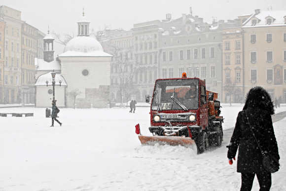 A snow-plough plows snow from the main market square after heavy snowfall in Krakow.