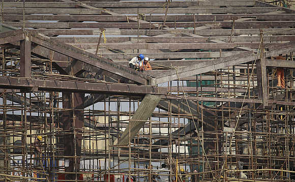 Labourers work at the construction site of a Metro station in Mumbai.