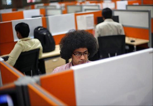 Employees work at their desks inside Tech Mahindra office building in Noida on the outskirts of New Delhi.