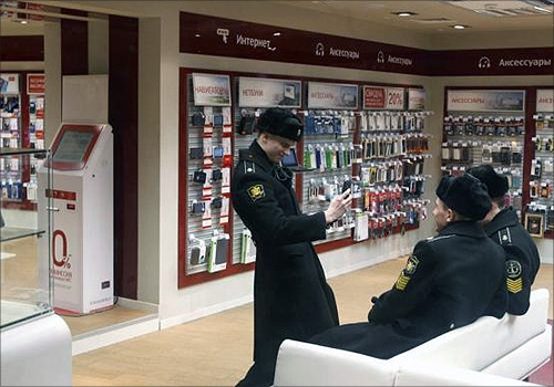 A Russian cadet uses a mobile phone to photograph other cadets in an MTS shop in St.Petersburg.