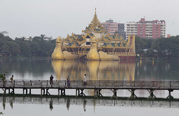 People walk on a wooden bridge in Kandawgyi Lake at Yangon in Burma.