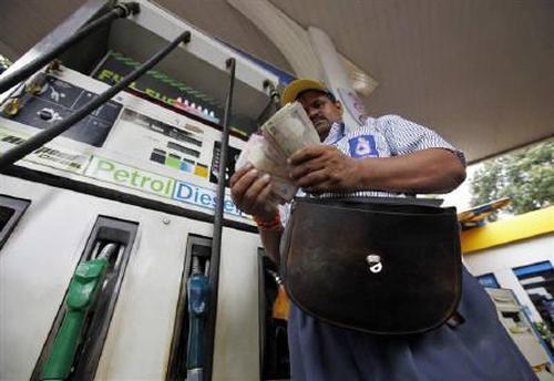 An employee counts Indian currency at a fuel station in Mumbai