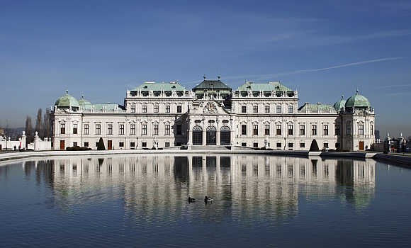 Ducks swim in a pond in front of the Upper Belvedere, a palace, in Vienna, Austria.
