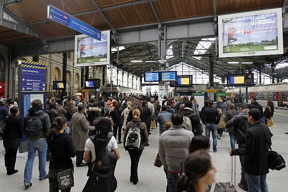 People wait for trains at the Gare Saint Lazare railway station in Paris, France.