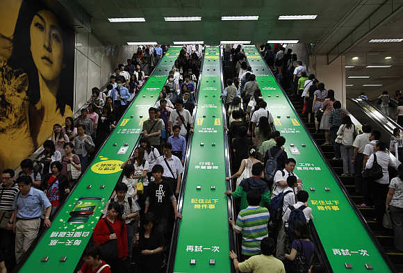 People ride on escalators inside a train station in Taipei, Taiwan.