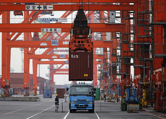 Workers load a container on a truck at a port in Tokyo, Japan.