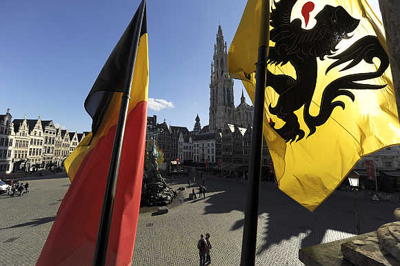 Belgian, left, and Flemish flag, right, are seen at the town square in Antwerp, Belgium.