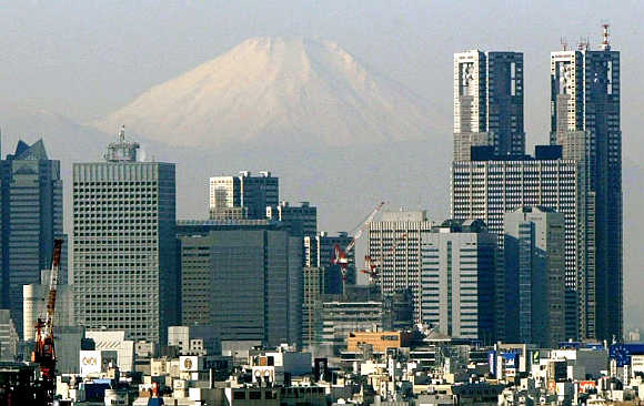 Mt Fuji looms over skyscrapers in Tokyo's Shinjuku district, Japan.
