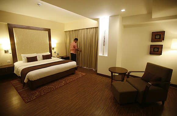 An employee prepares a room for guests at the Four Points hotel in Ahmedabad.