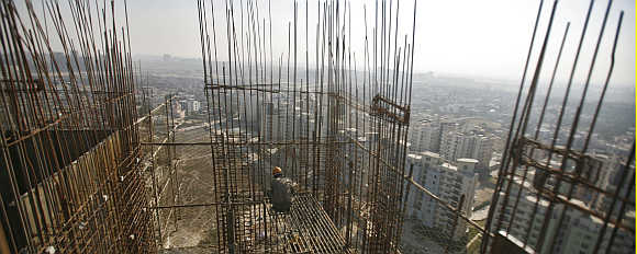 A labourer works at the construction site of a residential complex at Noida.