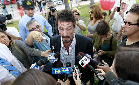 Computer software pioneer John McAfee speaks with reporters outside his hotel in Miami Beach, Florida.