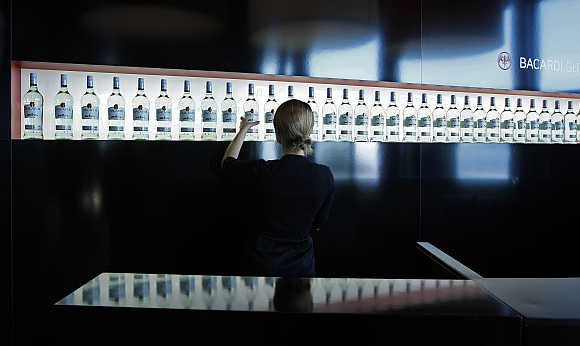 An exhibitor arranges Bacardi rum bottles in Cannes, southeastern France.