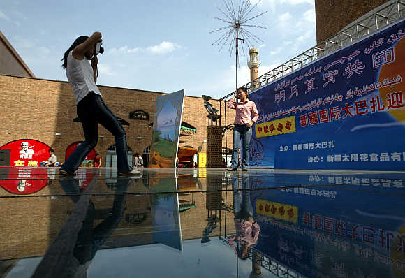 Tourists take pictures outside the Xinjiang International Bazaar, a major trading complex, in Urumqi, capital of northwest China's Xinjiang Uygur Autonomous Region.