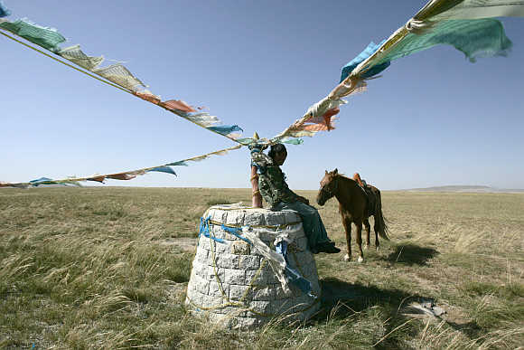 A shepherd rests in a pasture in Xilinhot in Inner Mongolia.